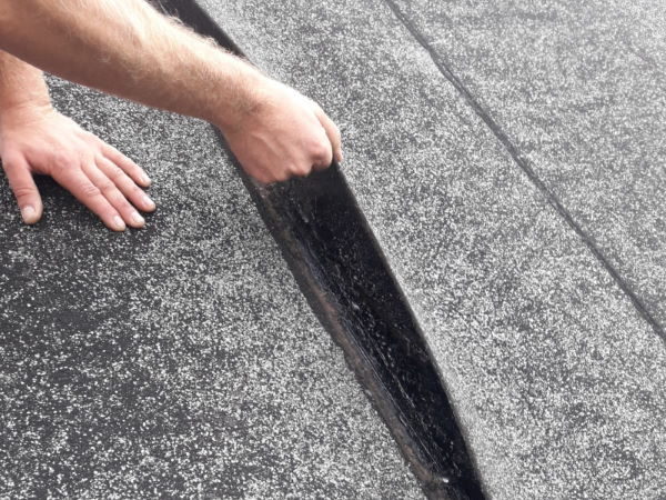 Een dakspecialist repareert het platte dak binnen korte tijd